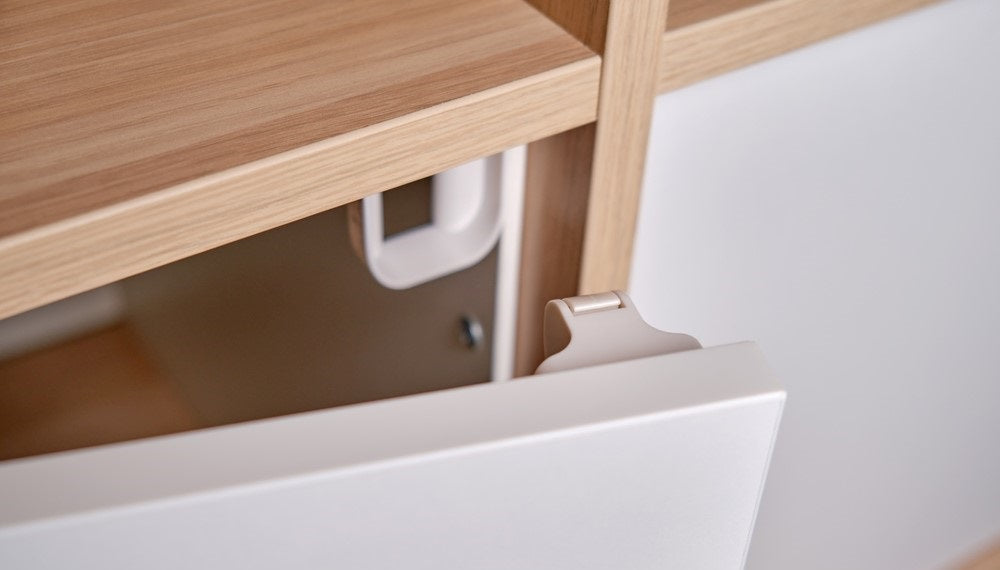 Magnetic child-proof lock in a white wooden cabinet door